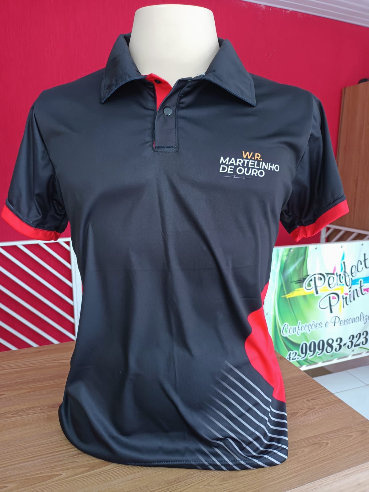 Polo preta e vermelha em malha dry personalizada com logotipo aplicado